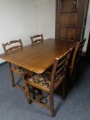 An Ercol elm and beech refectory dining table together with a set of four ladder back chairs in an