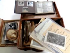 A vintage leather case containing paper ephemera to include postcards, monochrome photograph albums,
