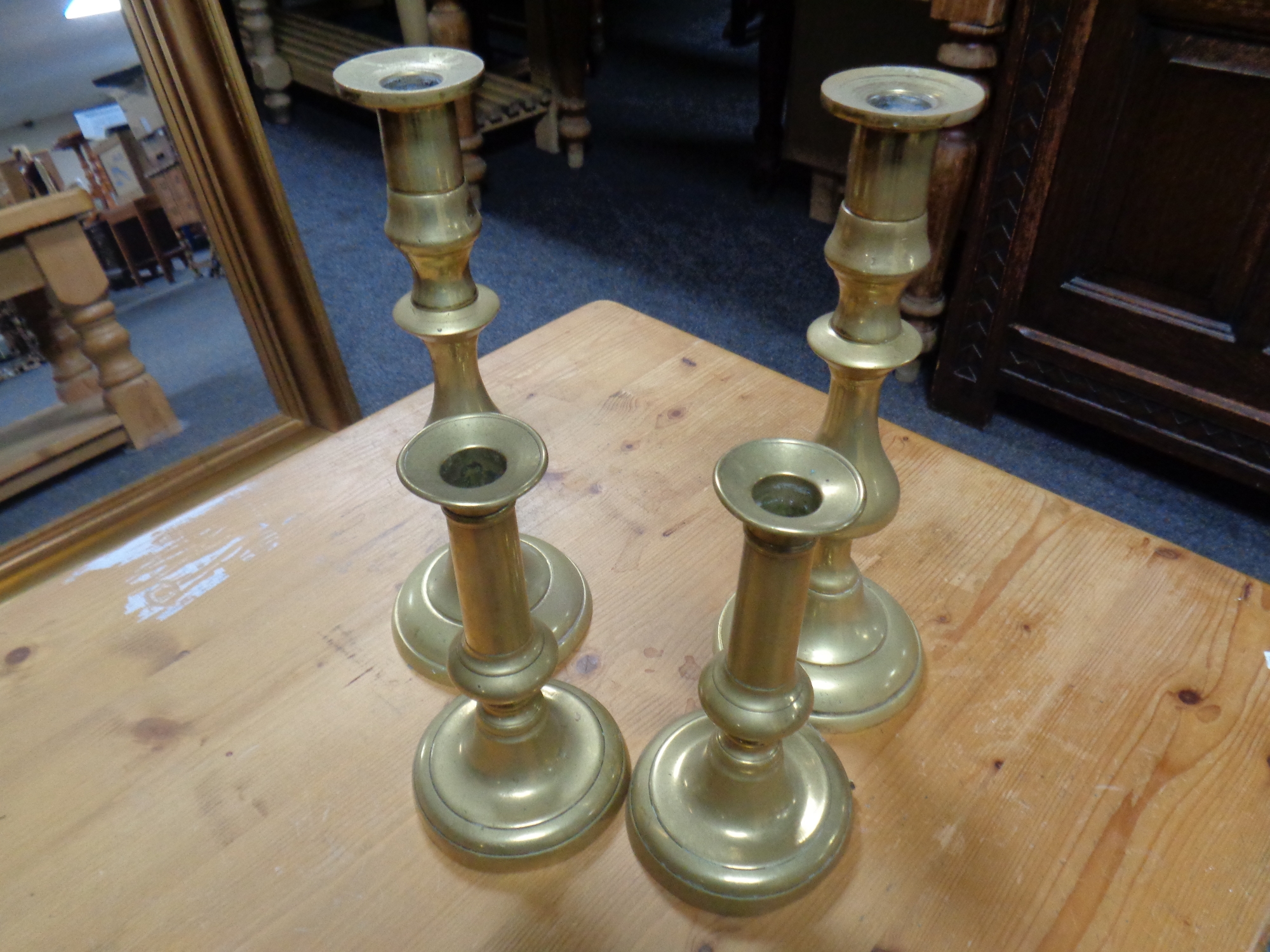 Two pairs of antique brass candlesticks