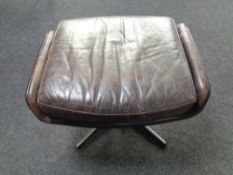 A 1970s continental brown leather footstool on a chrome pedestal