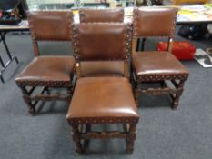A set of four 20th century oak dining chairs upholstered in a brown studded leather
