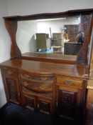 An Edwardian mahogany Arts and Crafts bow fronted mirror backed sideboard