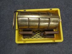 A crate containing two antique cast iron flat irons together with a brass four tier food carrier