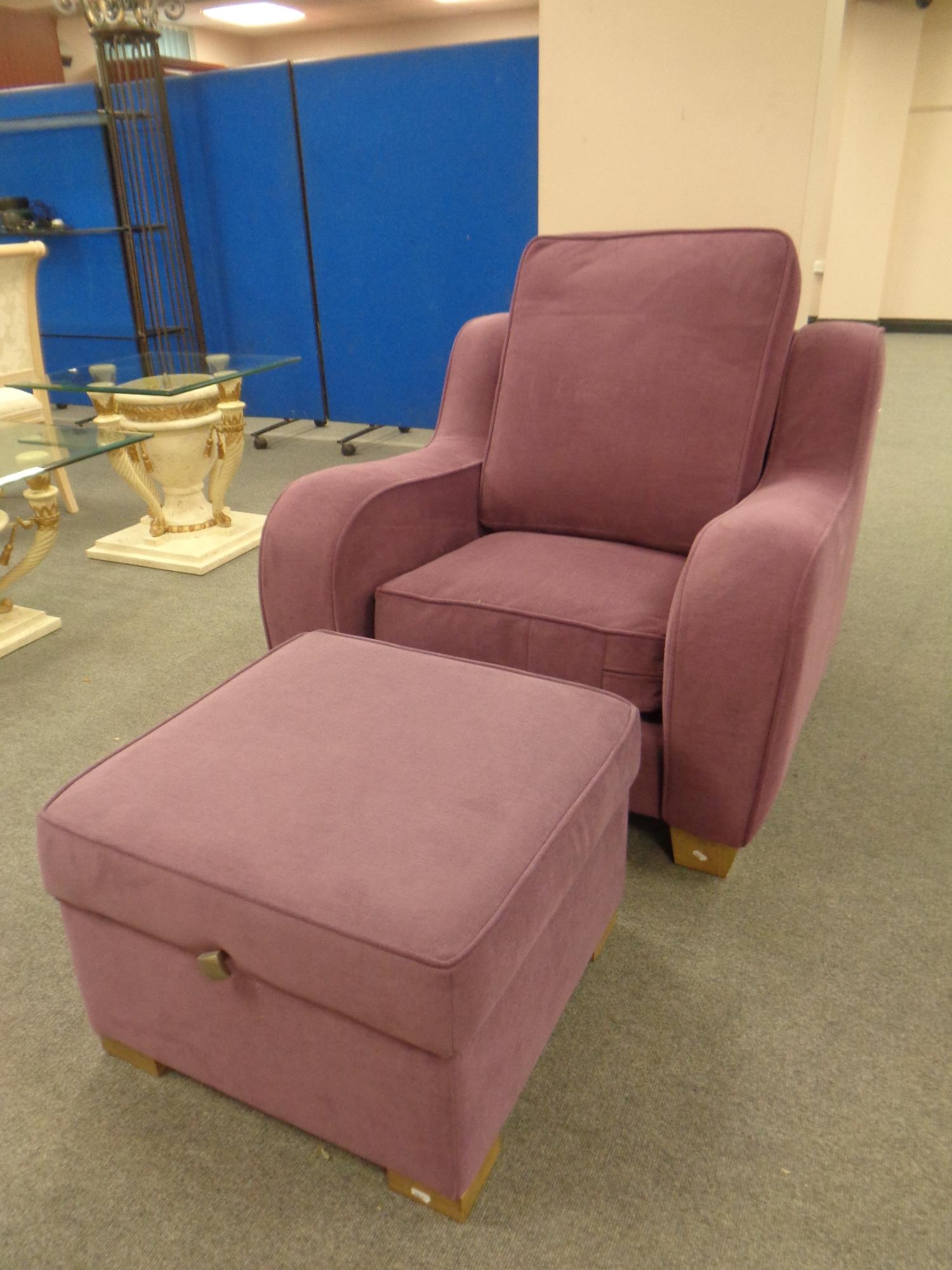 A contemporary armchair upholstered in a purple fabric together with a matching storage footstool