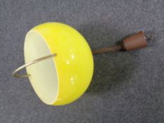 A 1970s pendant light fitting with yellow plastic shade