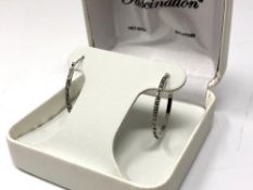 A pair of 14ct white gold diamond set hoop earrings.