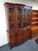 A Regency style inlaid mahogany four door glazed bookcase fitted cupboards and drawers beneath