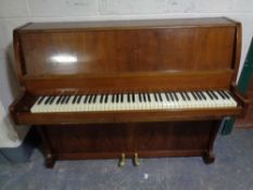 A teak cased piano