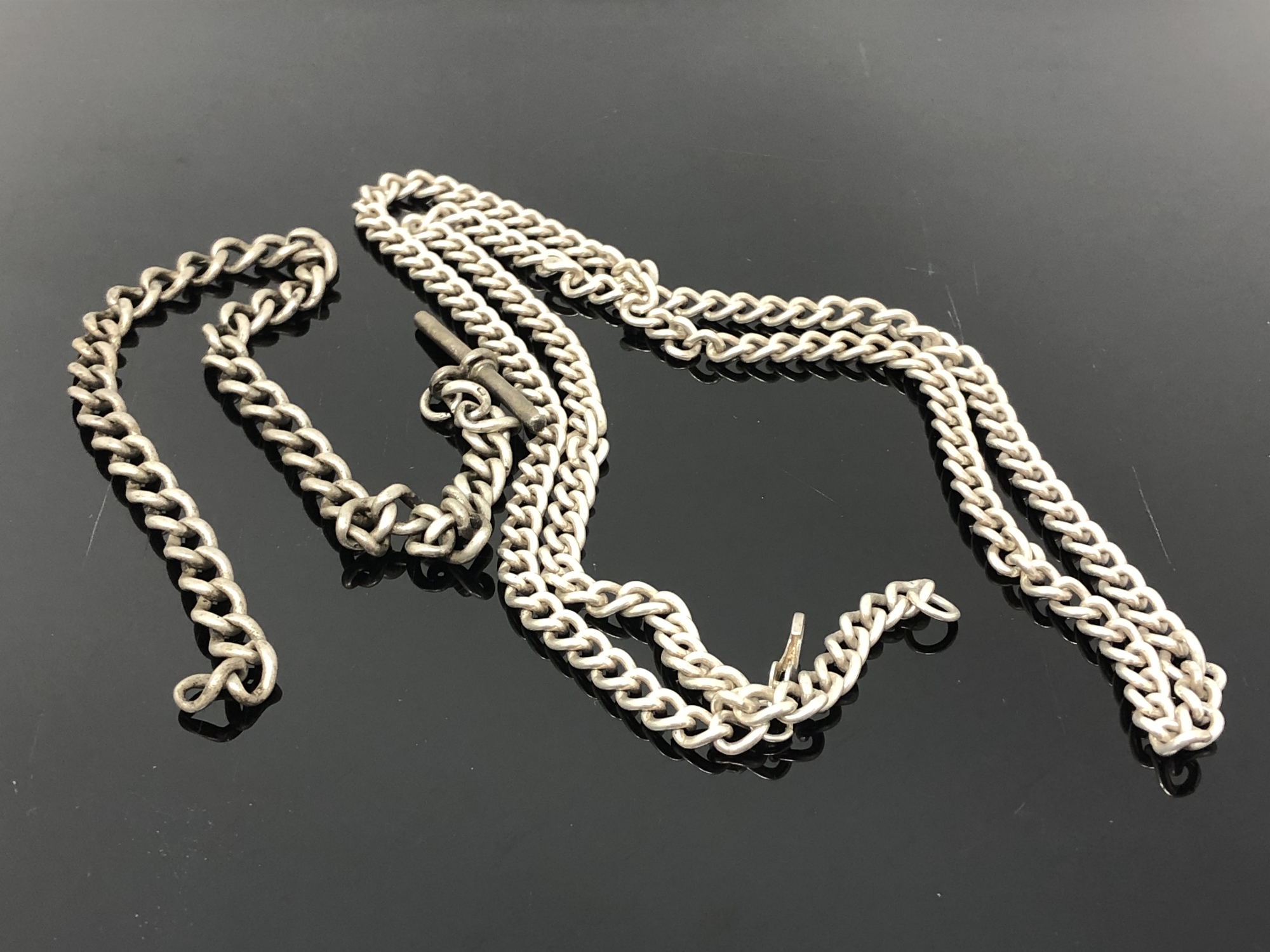 A heavy silver chain (catch broken) together with an antique silver Albert chain