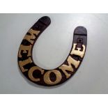 A cast iron Welcome horseshoe plaque