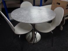 A circular marble topped bistro table on metal base together with a set of three white chairs on