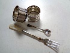 Two silver napkin rings together with a silver mustard spoon and silver pickle fork (af)