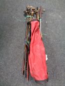 A vintage golf bag containing a quantity of vintage golf clubs to include hickory shafted clubs