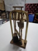 A four piece brass Art Deco companion set on stand