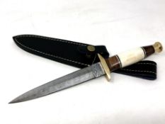 A commando style knife with Damascus steel blade, camel bone,
