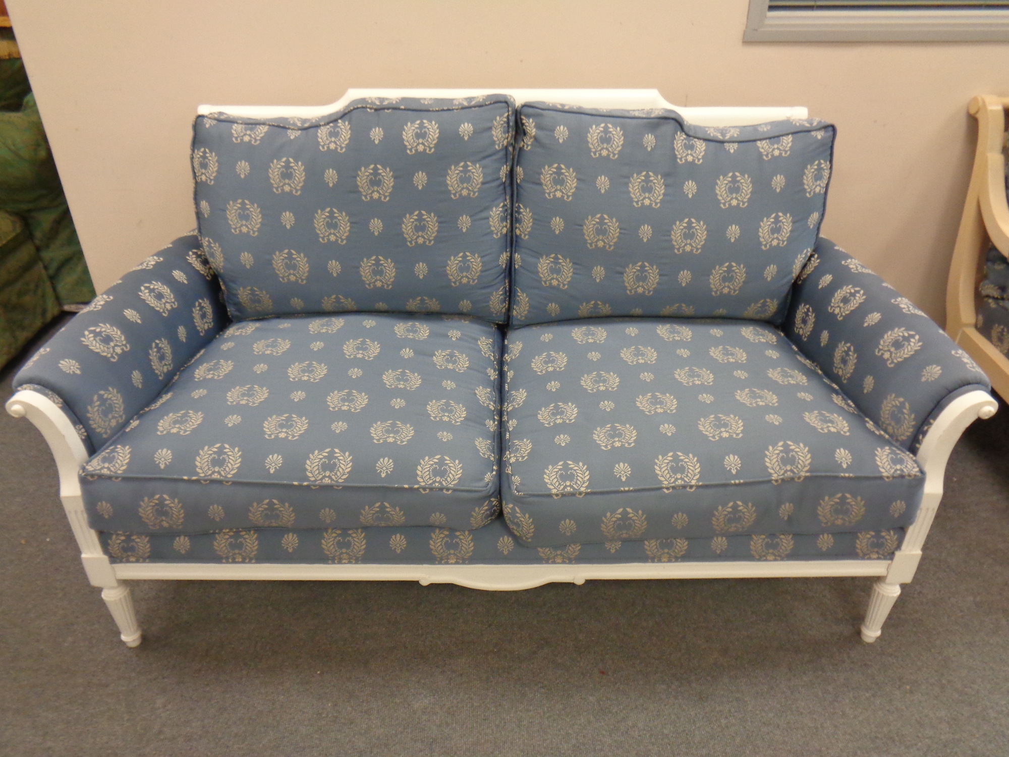 A wood framed French style two seater salon settee upholstered in a classical blue and gold fabric