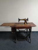 A 20th century Singer treadle sewing machine in oak table