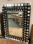 A contemporary mirror with circular mirrored frame,