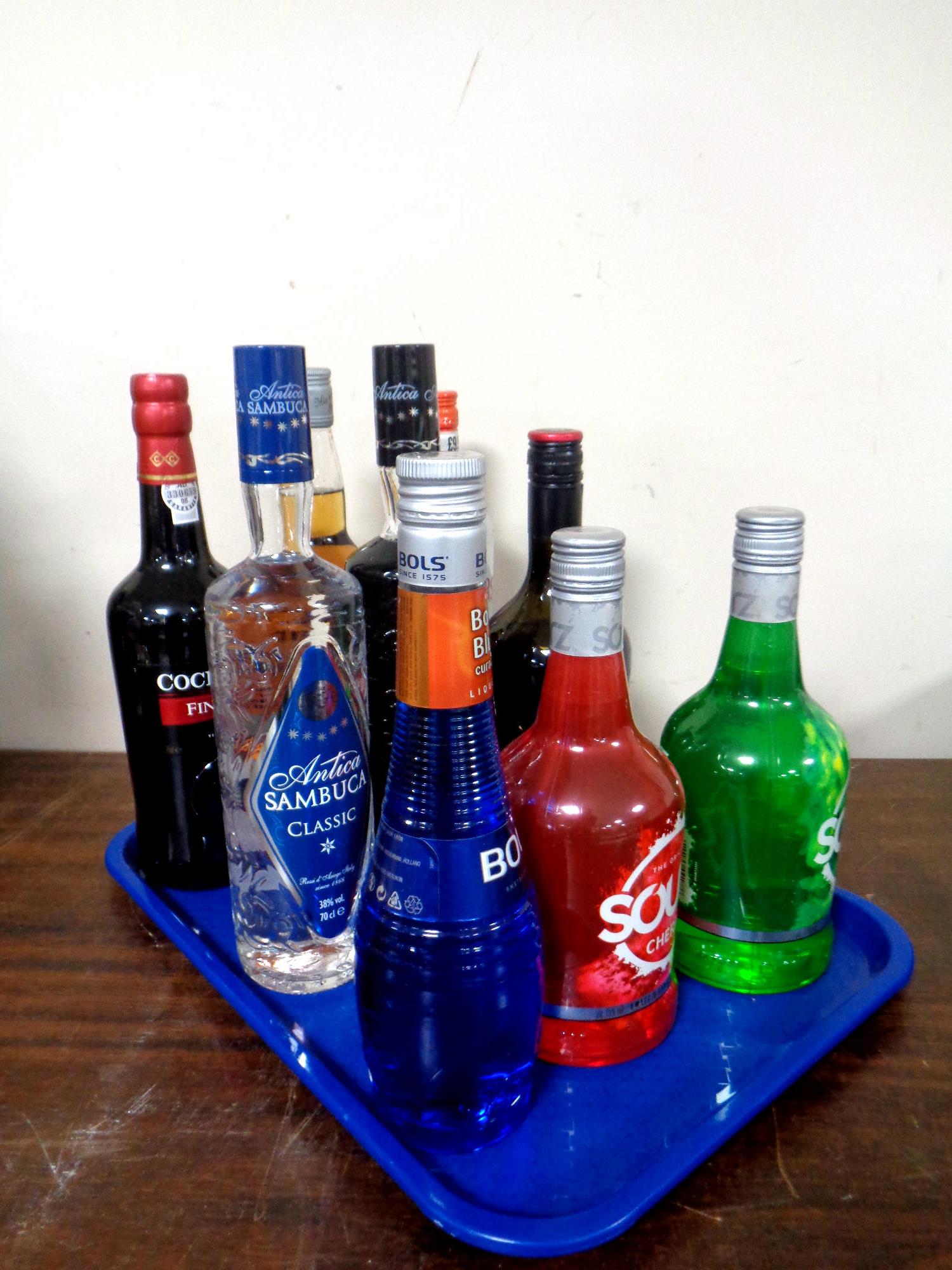 A tray containing nine bottles of alcohol to include Cockburn's Port (75cl),