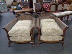 A pair of Edwardian carved beech framed bergere armchairs