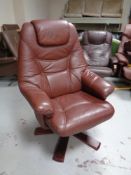 A late 20th century swivel armchair upholstered in burgundy leather