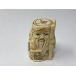 A carved Chinese bone netsuke - Gentleman carrying a staff and scroll