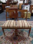 A pair of early 20th century Regency style dining chairs upholstered in a striped fabric