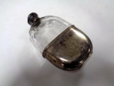 A silver plated and glass hip flask with silver collar and top