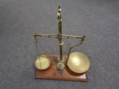 A set of 19th century brass balance scales with weights mounted on a mahogany board