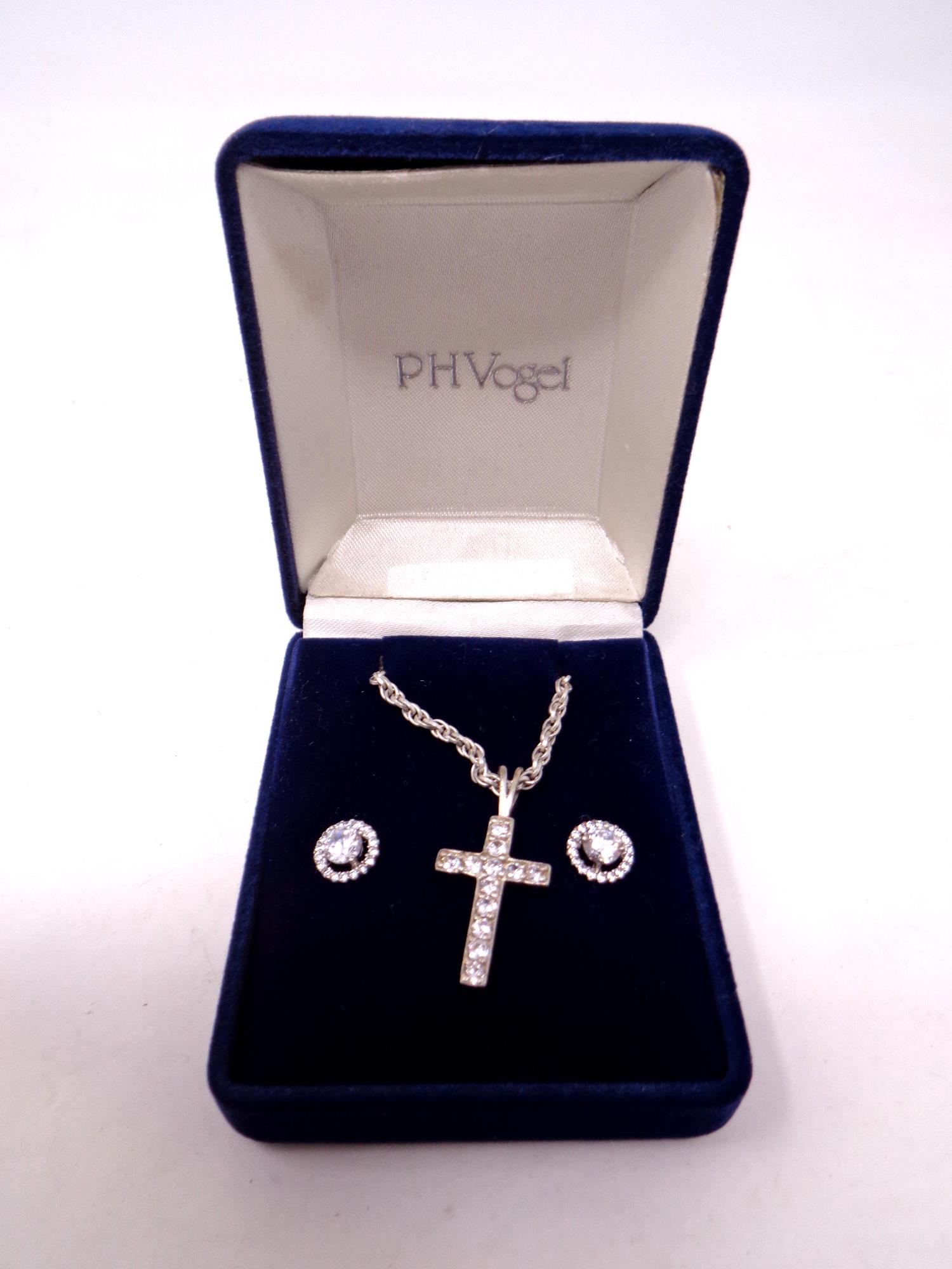 A silver cross on chain together with cluster earrings