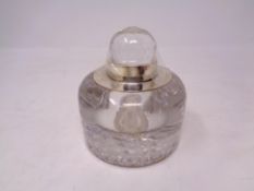 A heavy glass ink well with silver rim