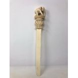 A large 19th century Indian ivory page turner with carved terminal elephant figure on stepped