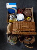 Two boxes containing 20th century enamelled teapots, wicker hamper with contents, place mats,