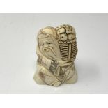 A carved Chinese bone netsuke - Village elder carrying a basket of food