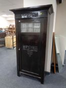 An antique stained pine hall cupboard with a leaded glass door