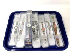 A group of seven various Swatch watches in plastic cases.