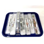 A group of seven various Swatch watches in plastic cases.