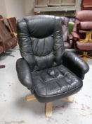 A late 20th century swivel armchair upholstered in black leather