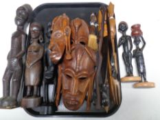 A tray containing a quantity of carved hardwood tourist tribal figures and masks