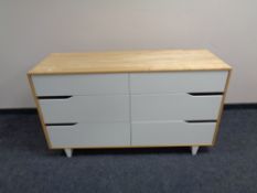 A contemporary pine effect six drawer chest