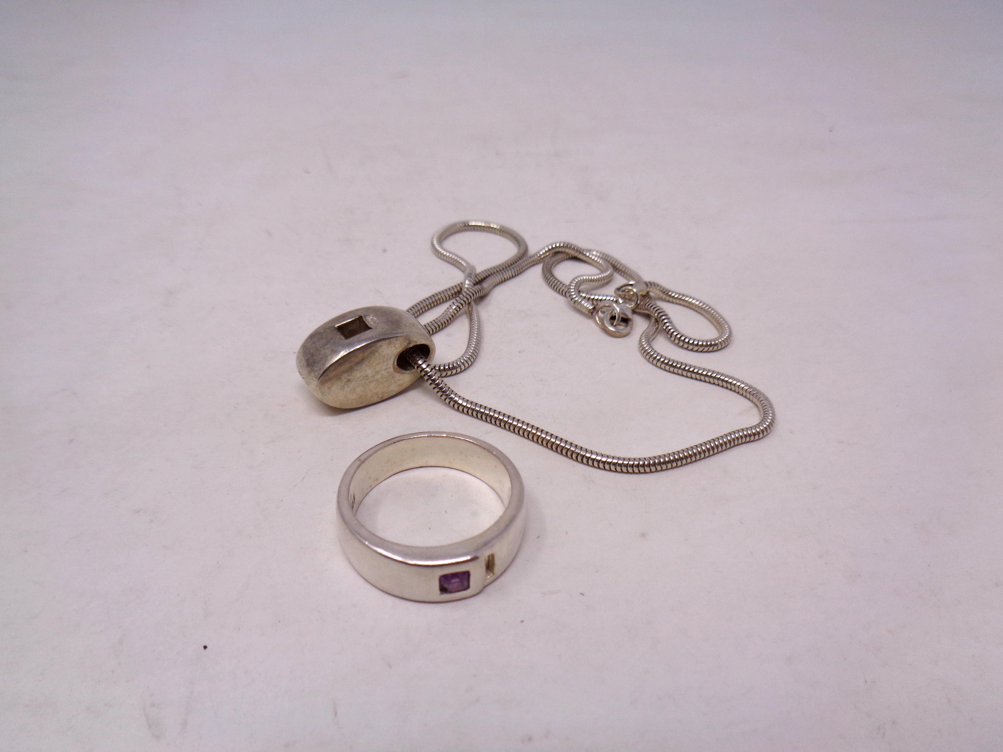 A silver ring pendant on chain