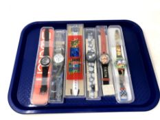 A group of six various Swatch watches in plastic cases.