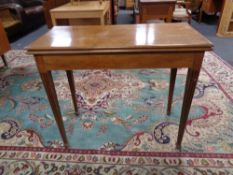A 19th century mahogany turnover top tea table on tapered legs