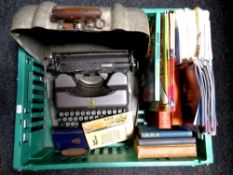 A crate containing a vintage metal cased typewriter, assorted books, Viz comics,