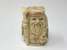 A carved Chinese bone netsuke - Gentleman holding a staff