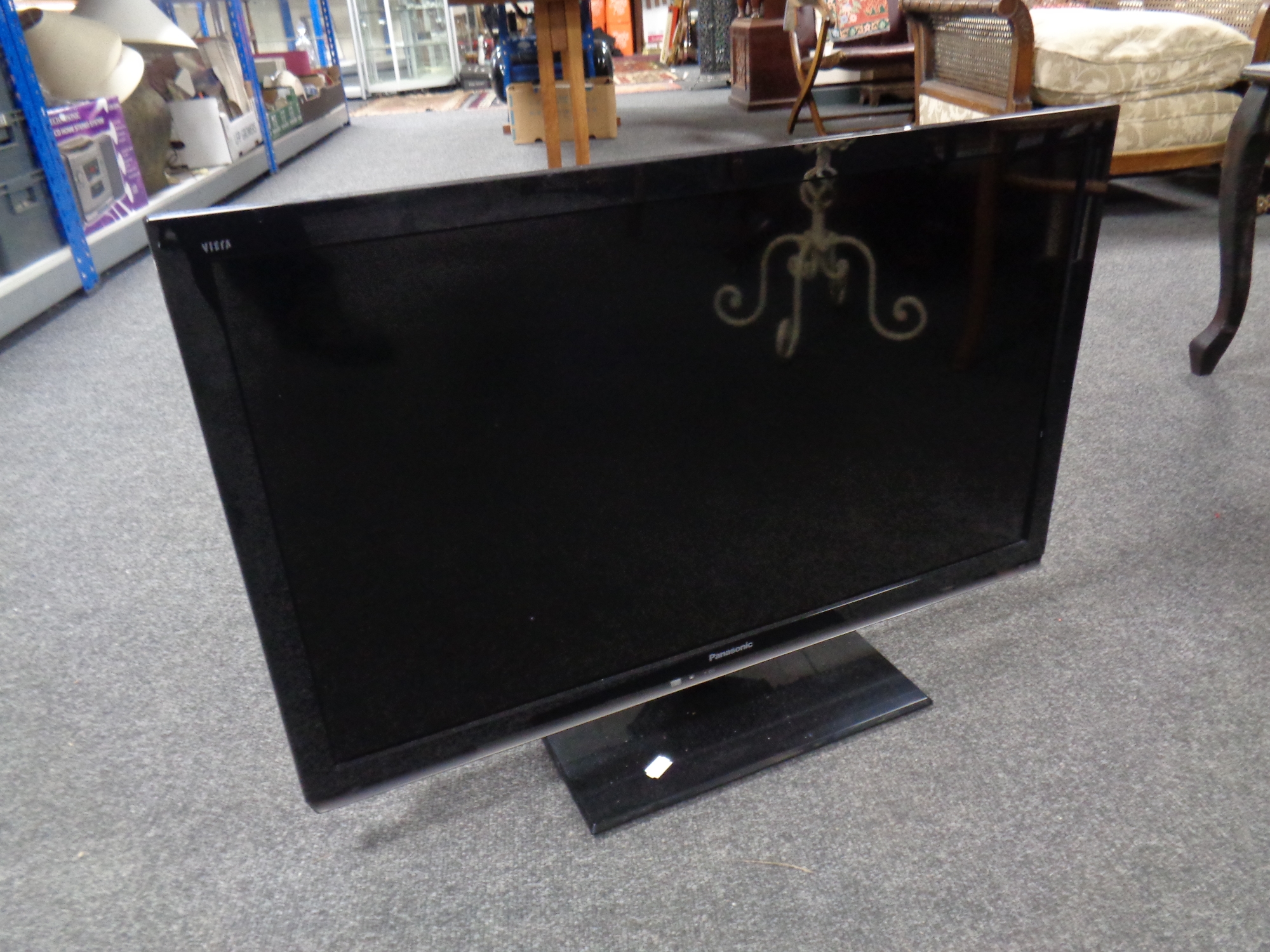 A Panasonic TX-L32X5B LCD TV with remote on stand,