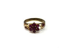 A ruby cluster ring on yellow metal shank,