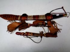 Three African knives in tasseled leather sheaths