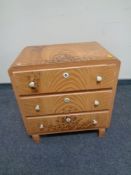 A 20th century pine three drawer chest in a scumbled finish