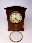 An inlaid mahogany American mantel clock on raised brass feet (door a/f)